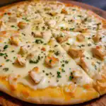 Delicious homemade chicken and cheese pizza topped with fresh herbs, perfect for any meal. Easy to make with your favorite ingredients for a tasty, comforting treat.