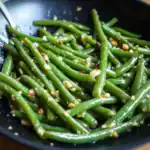 Fresh green beans sautéed with garlic, red pepper flakes, and olive oil, creating a flavorful and healthy side dish perfect for any meal.