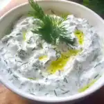 Creamy cucumber yogurt dip garnished with fresh dill and a drizzle of olive oil, perfect for appetizers, snacks, or party platters. Refreshing, savory, and easy to make with fresh ingredients.