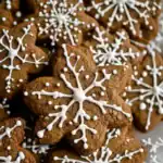 Decorated gingerbread cookies with white icing snowflake designs for holiday baking. Perfect for Christmas treats or holiday parties, these homemade cookies are easy to make and delicious.