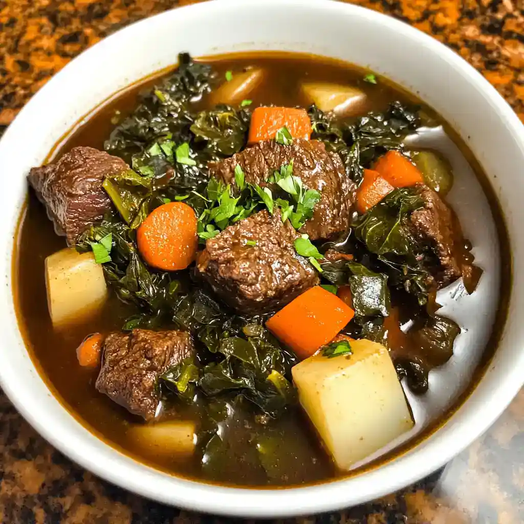 Hearty beef stew with carrots, potatoes, and greens in a rich broth, served in a white bowl. Perfect comfort food for cold days.