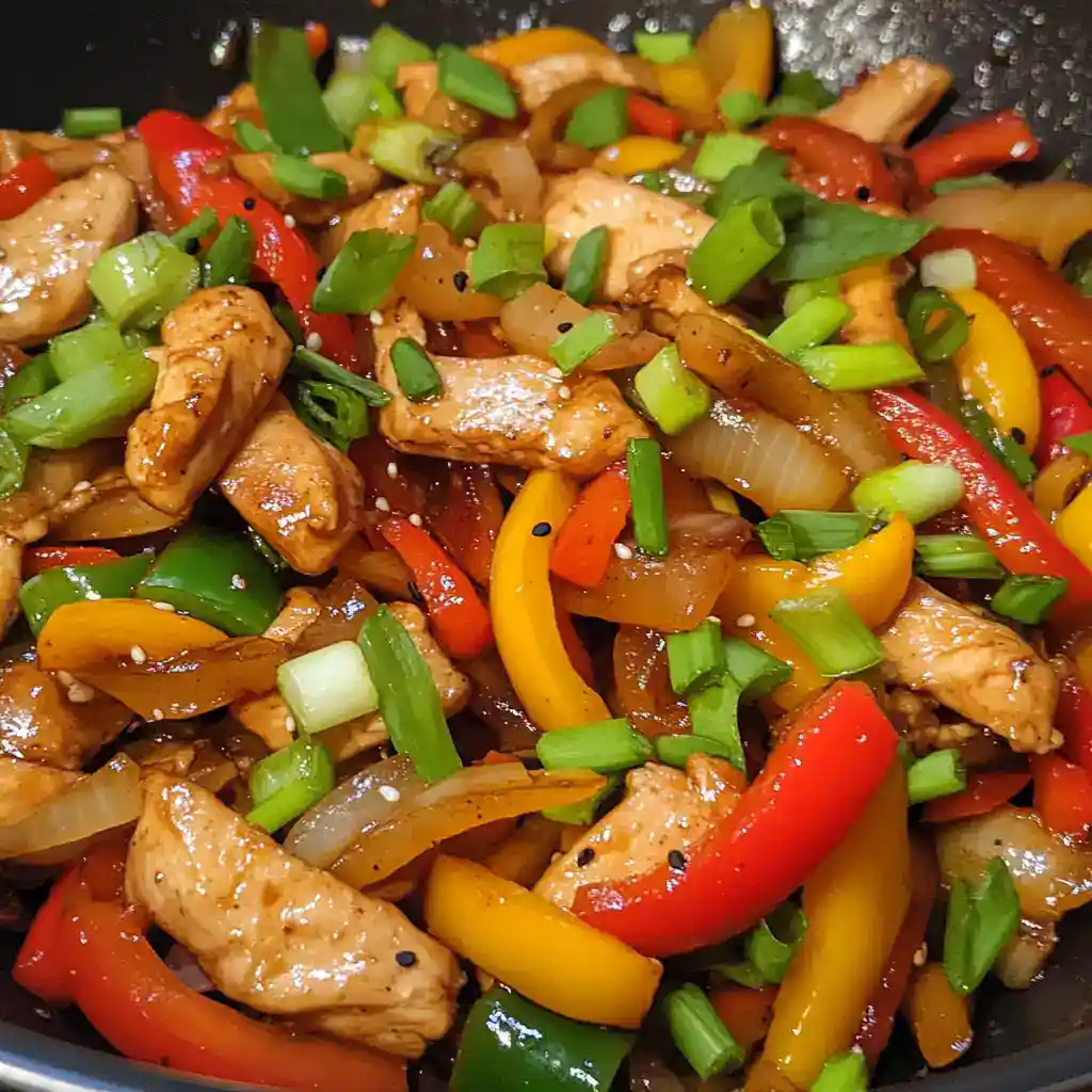 Fried chicken with colorful bell peppers, onions, and green onions, cooked to perfection for a quick and healthy meal.
