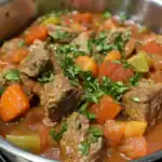 Hearty beef stew with tender beef chunks, carrots, celery, and fresh herbs in a rich tomato-based broth. Perfect comfort food for cold days.