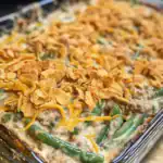 Delicious green bean casserole topped with crispy fried onions and melted cheese, perfect for family dinners and holiday celebrations.